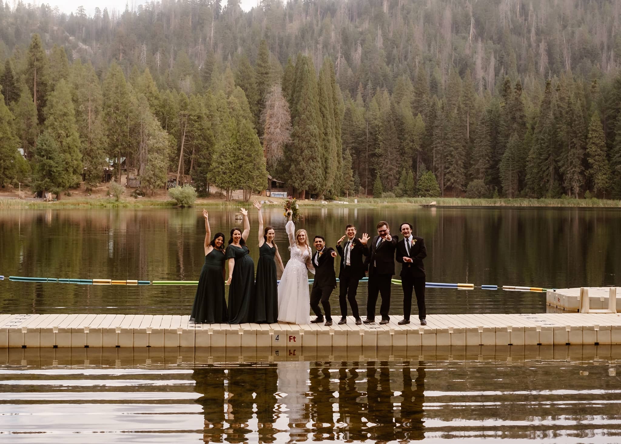 Wedding guests celebrating on lake dock.