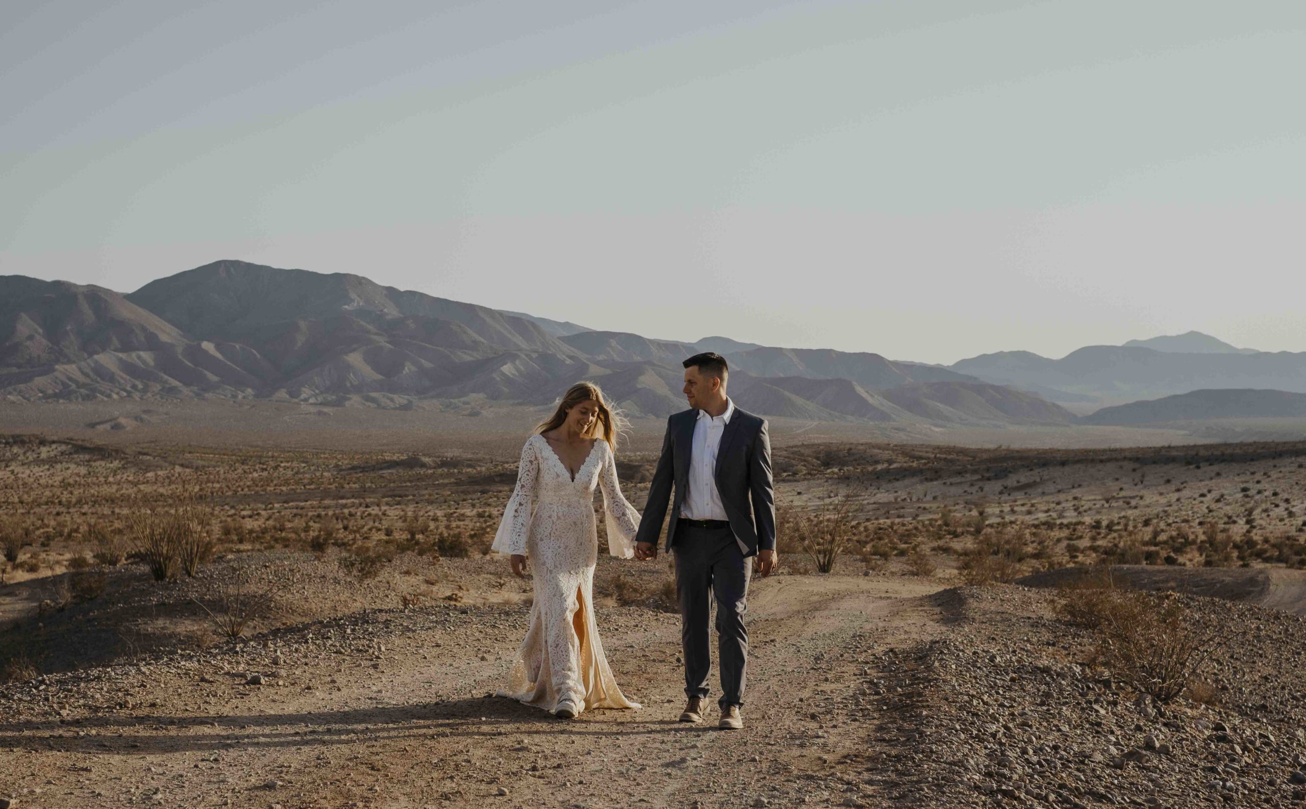 Hiking elopement couple holding hands in Anza Borrego desert.